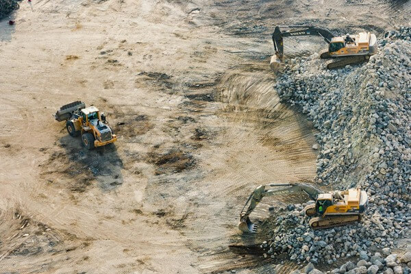 Vista aérea de maquinaria pesada excavando terreno para obra civil en Tijuana.